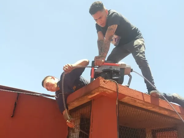Plomeros de AFA con equipo de desazolve en la azotea de un edificio