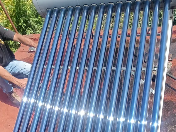Plomero de AFA colocando los tubos al vacío de un calentador solar